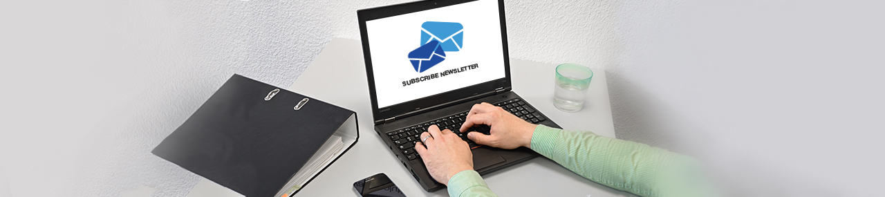 A person working on a computer with the words "Newsletter" on the screen.