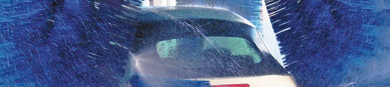 A car going through a car wash with for arms cleaning it from all sides.